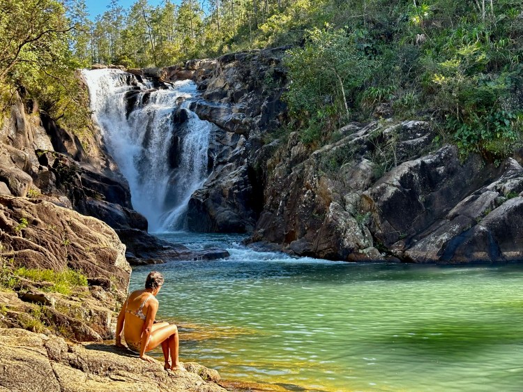 Woman at a waterfall pool in Mountain Pine Ridge.